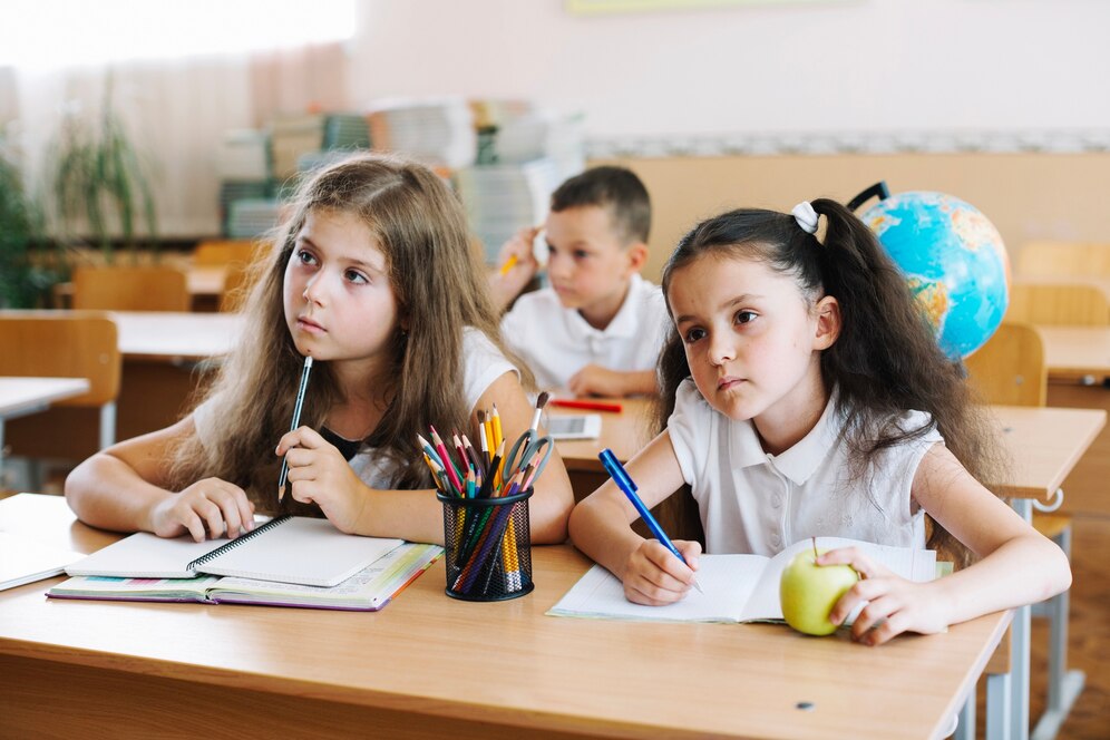 schoolchildren-studying-classroom-sitting-desks_23-2147663485